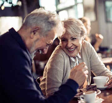 Couple laughing and enjoying a cup of coffee